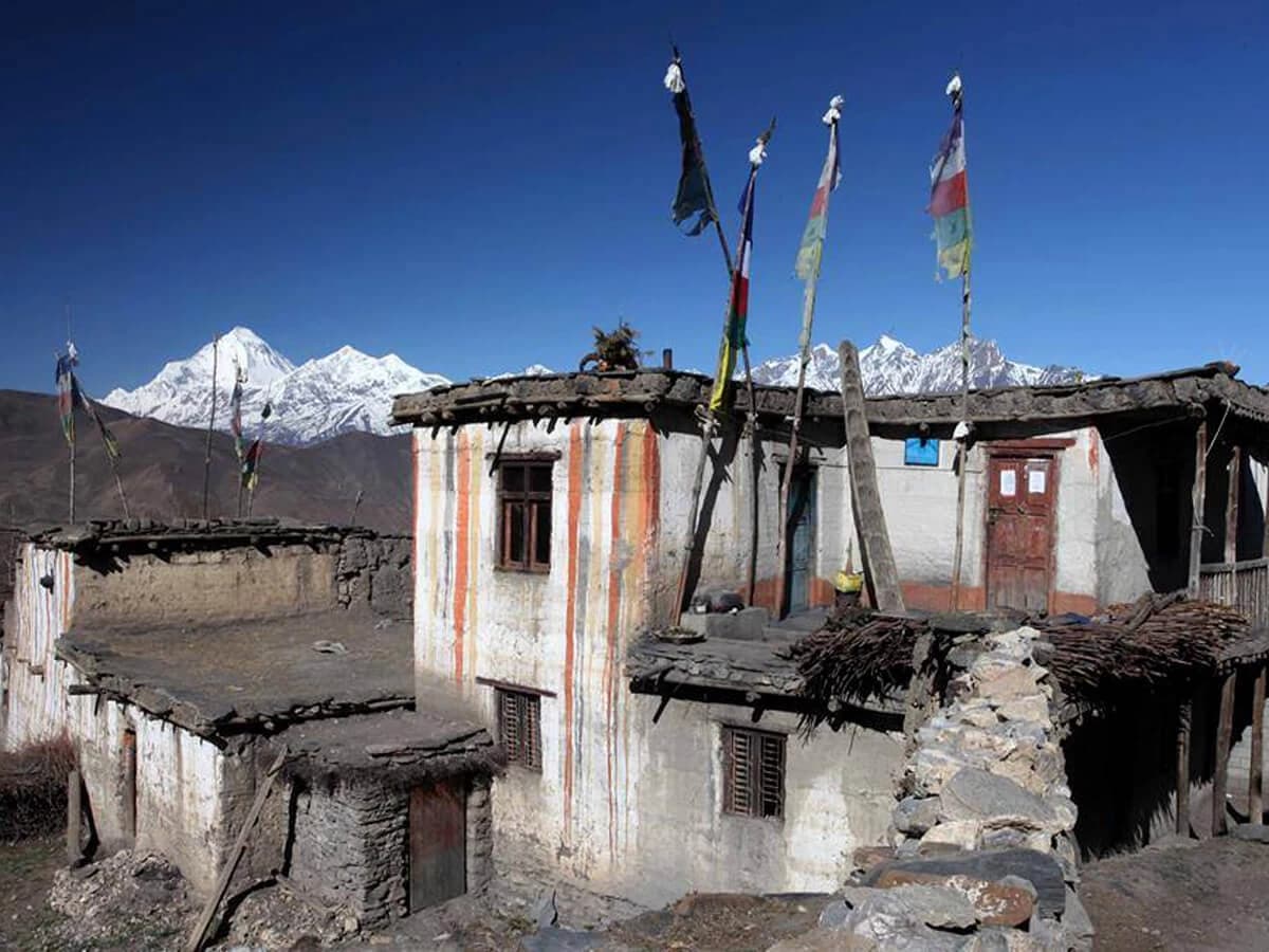 A clay-roofed traditional house in Jharkot and mountain in backdrop